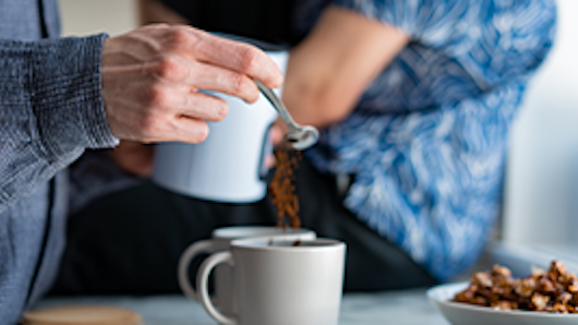 Person making coffee on kitchen counter.