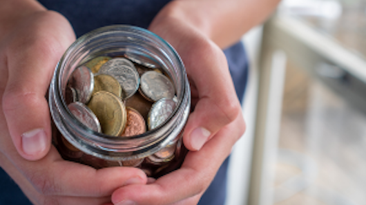 Image of a woman holding a jar full of coins