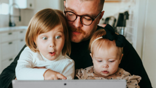 Image of father and kids looking at a laptop
