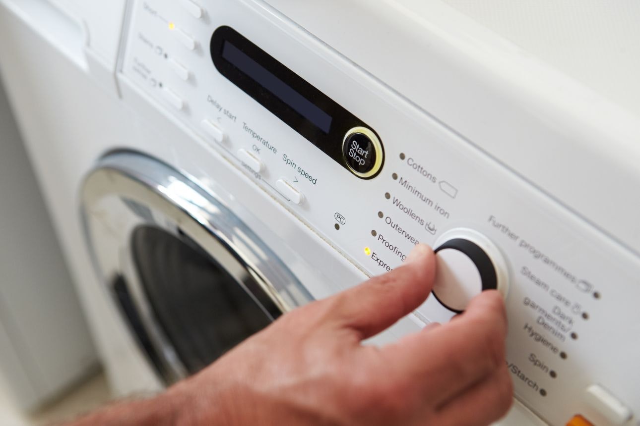 Image of a person turning on their washing machine