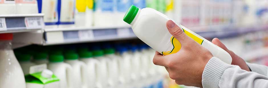 Looking at best-before date on milk bottle in supermarket.