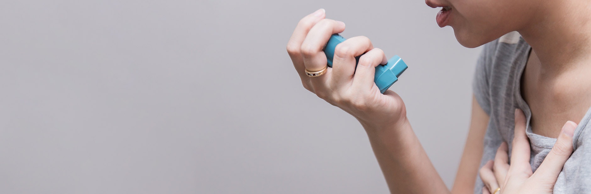 Woman using inhaler for asthma