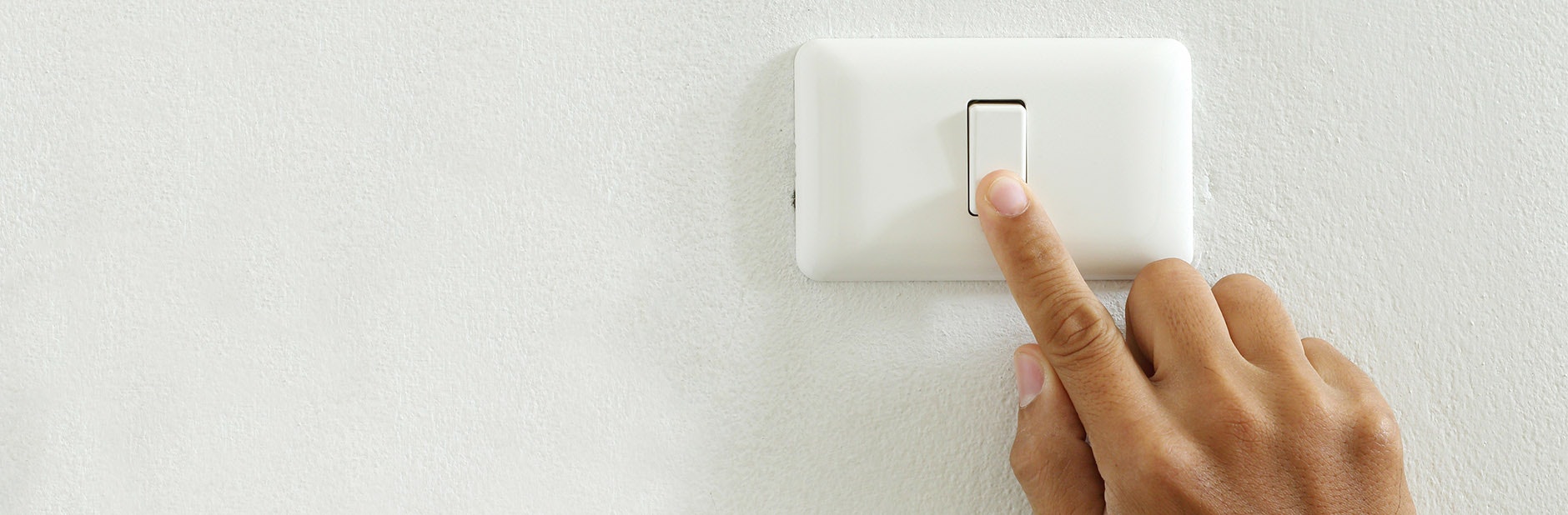 hand pressing a switch on wall