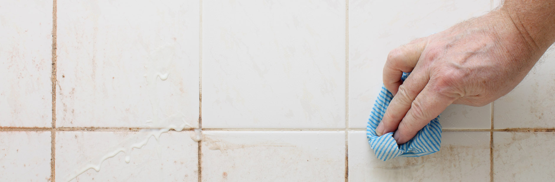 wiping dirty bathroom tiles