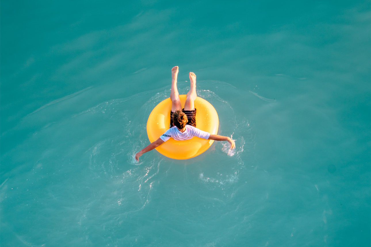 Kid floating in the ocean.