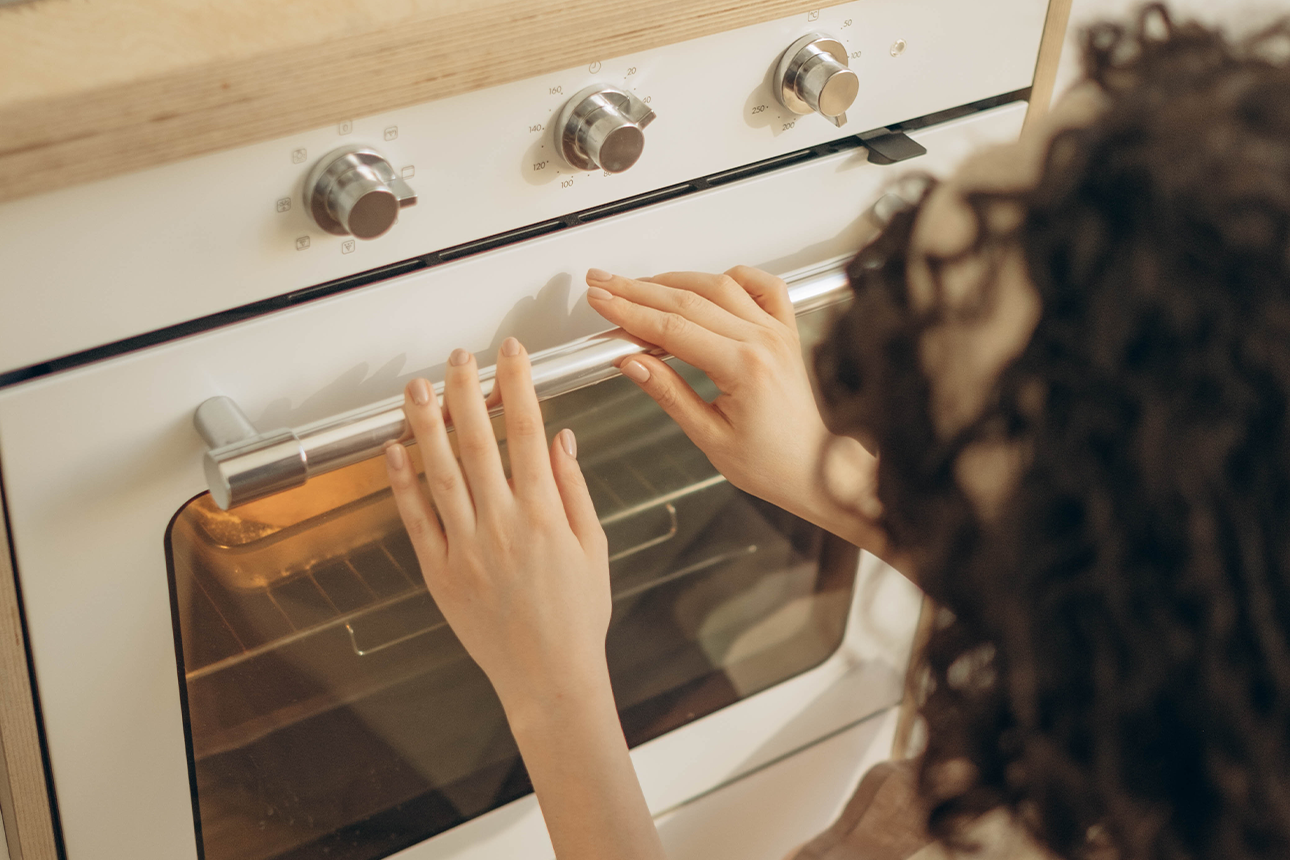 Woman using oven at home.