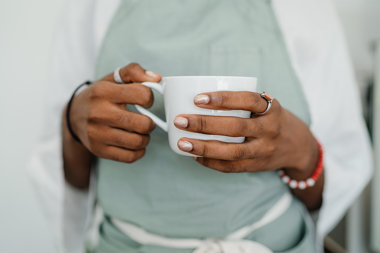 Person holding cup of coffee.