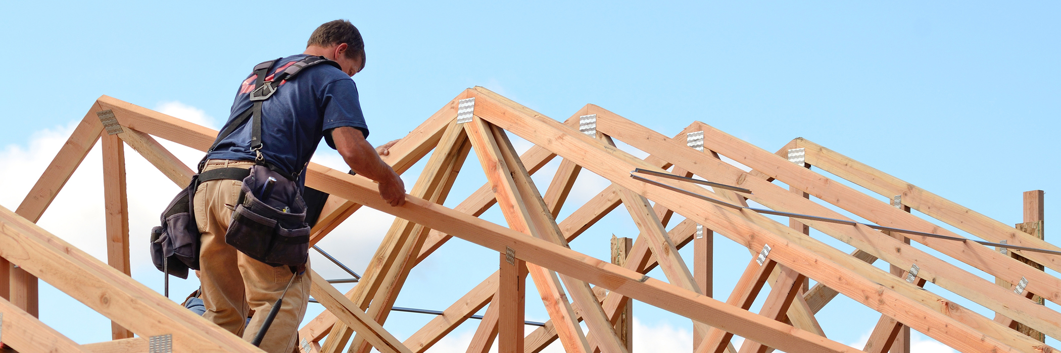 Construction builder working on roof frame.