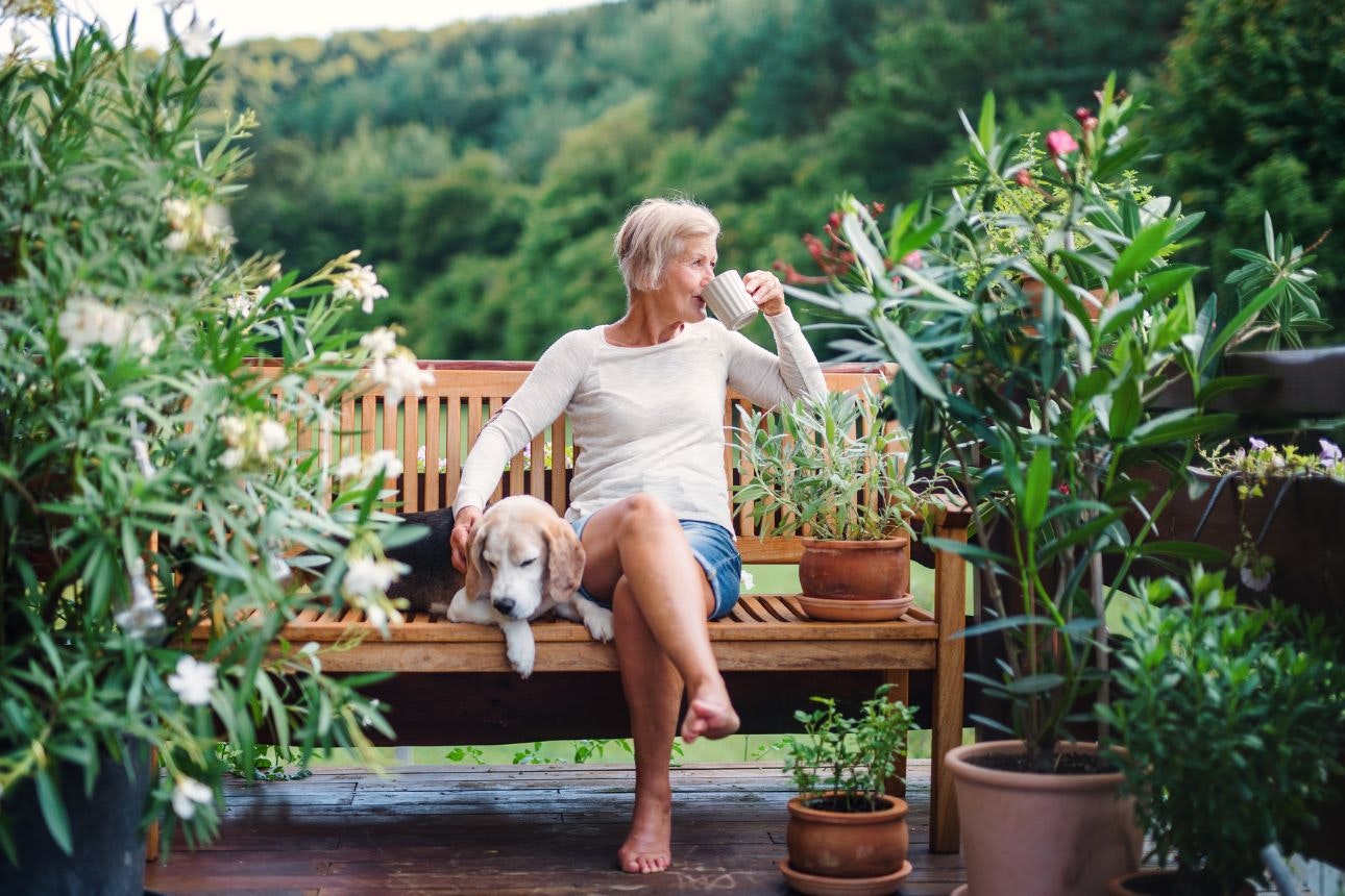 Image of a woman drinking tea next to her dog