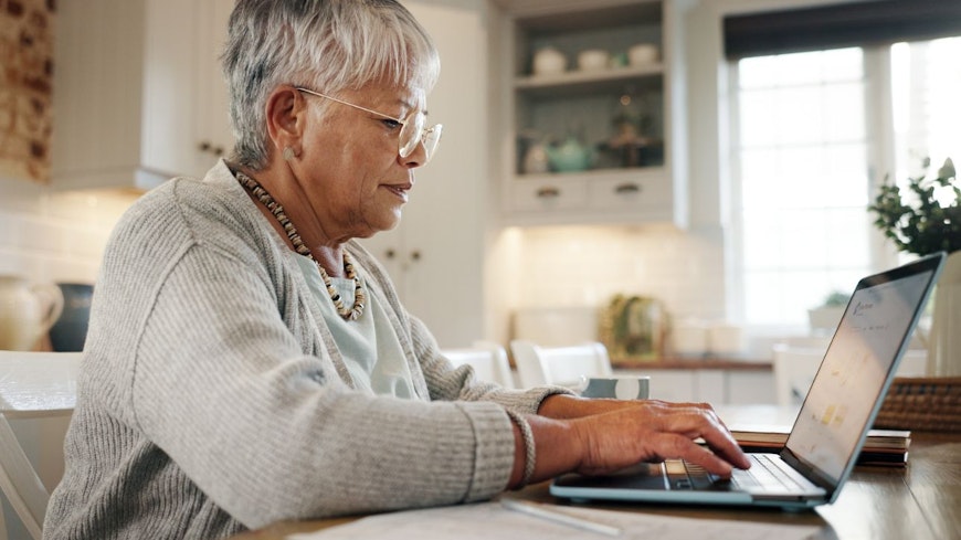 Consumer nz website promo image a woman reviews her retirement plan on a computer in her home width