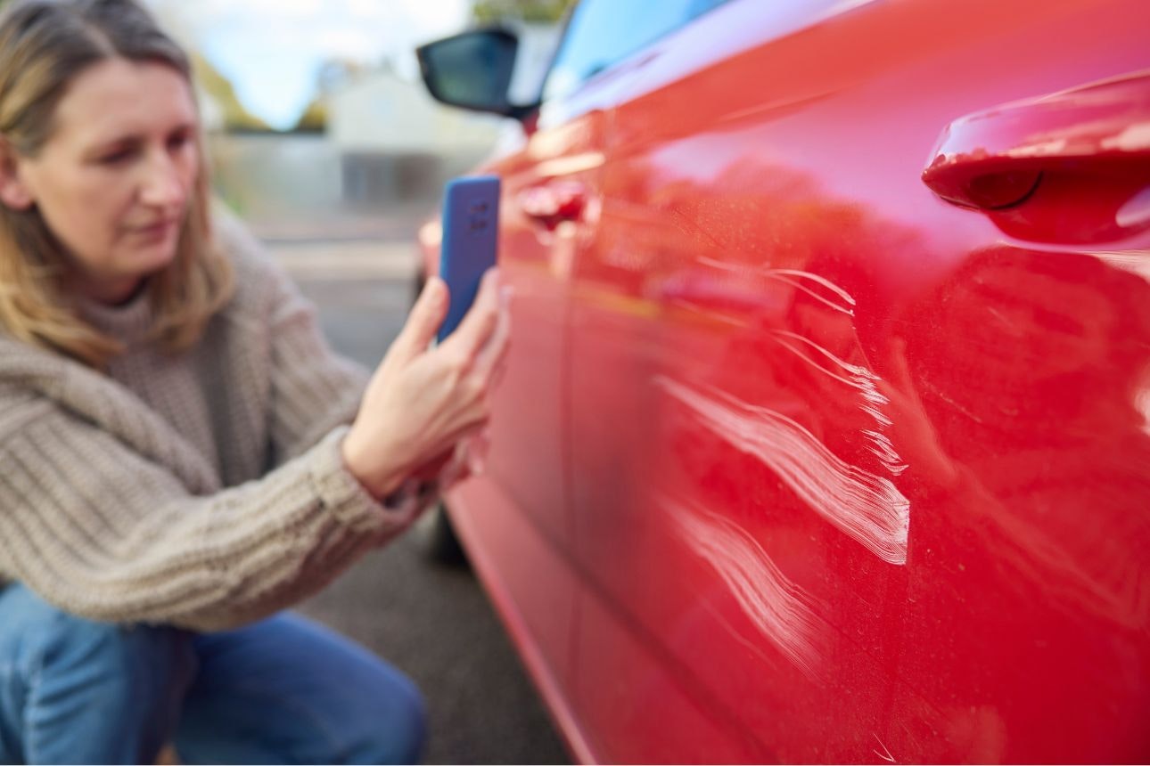 Consumer nz website promo image a woman takes a photo of damage caused to a car for insurance purposes width