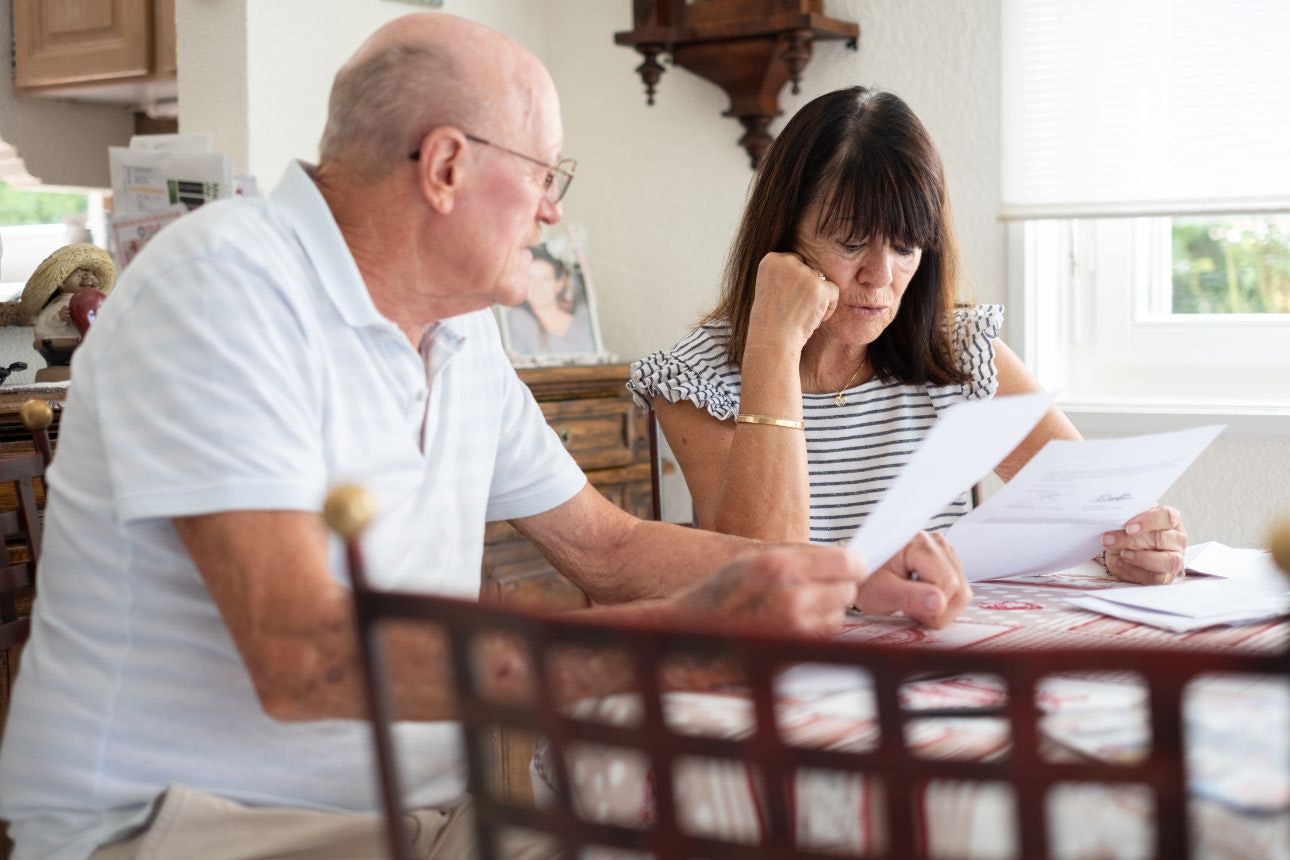 Consumer nz website promo image senior couple sitting at home table managing insurance width
