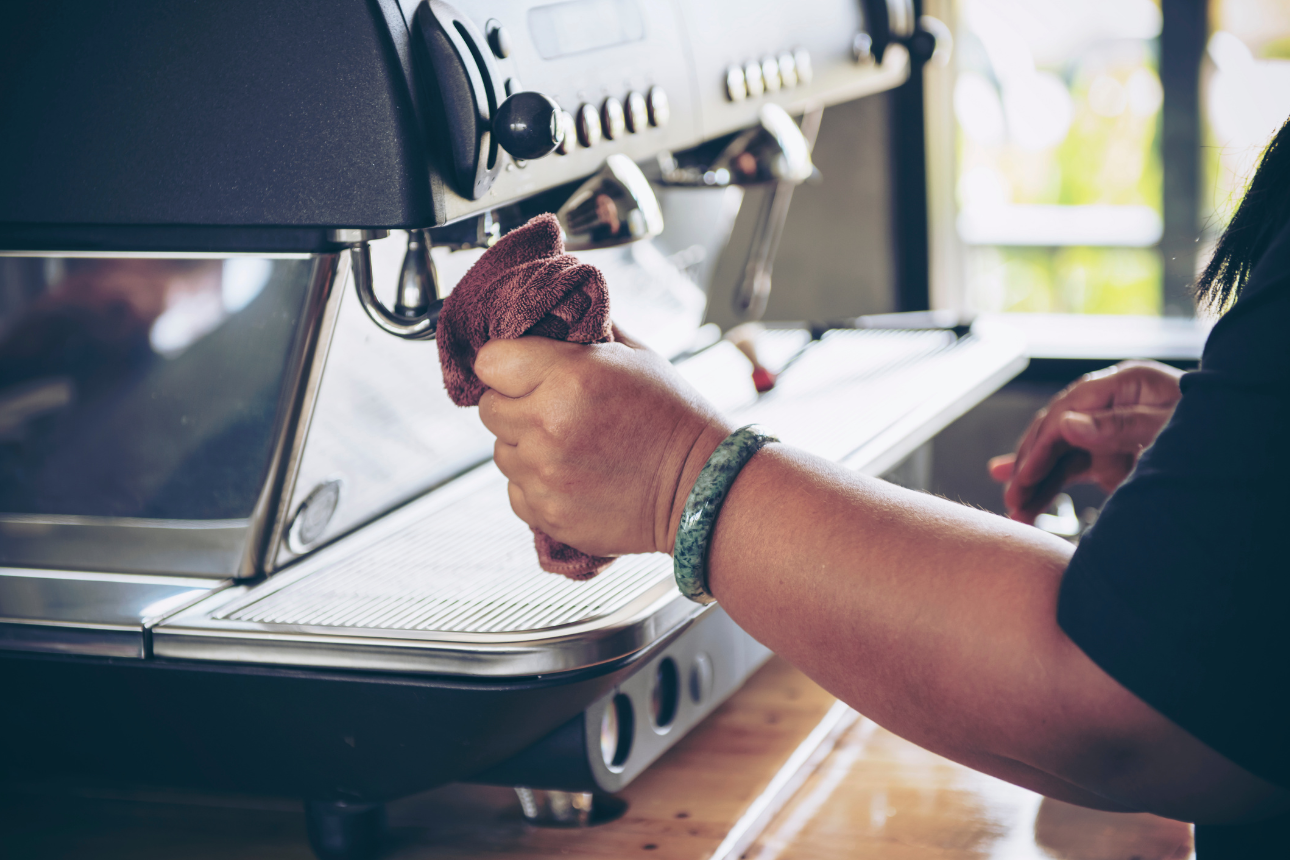 Image of woman cleaning a coffee machine