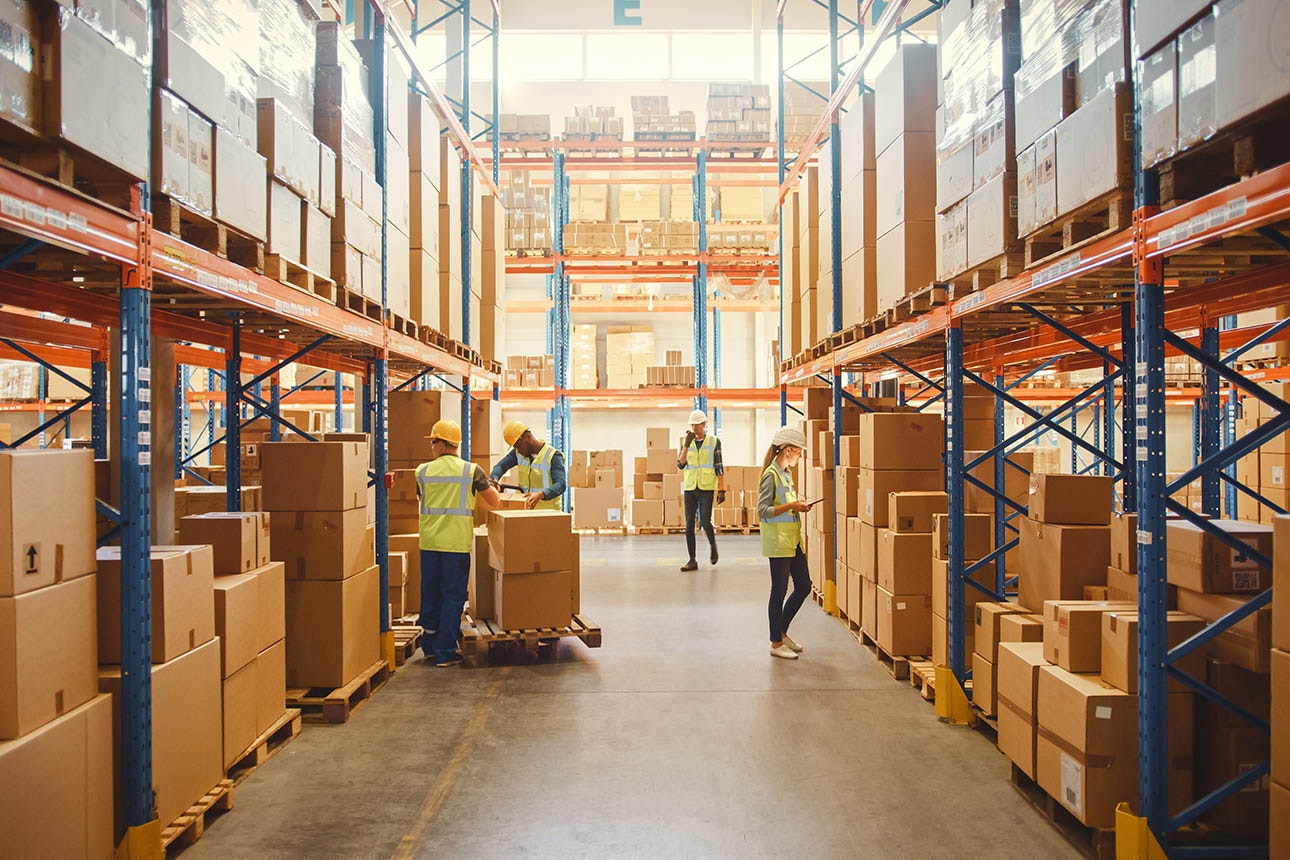 A warehouse with workers moving boxes of stock.