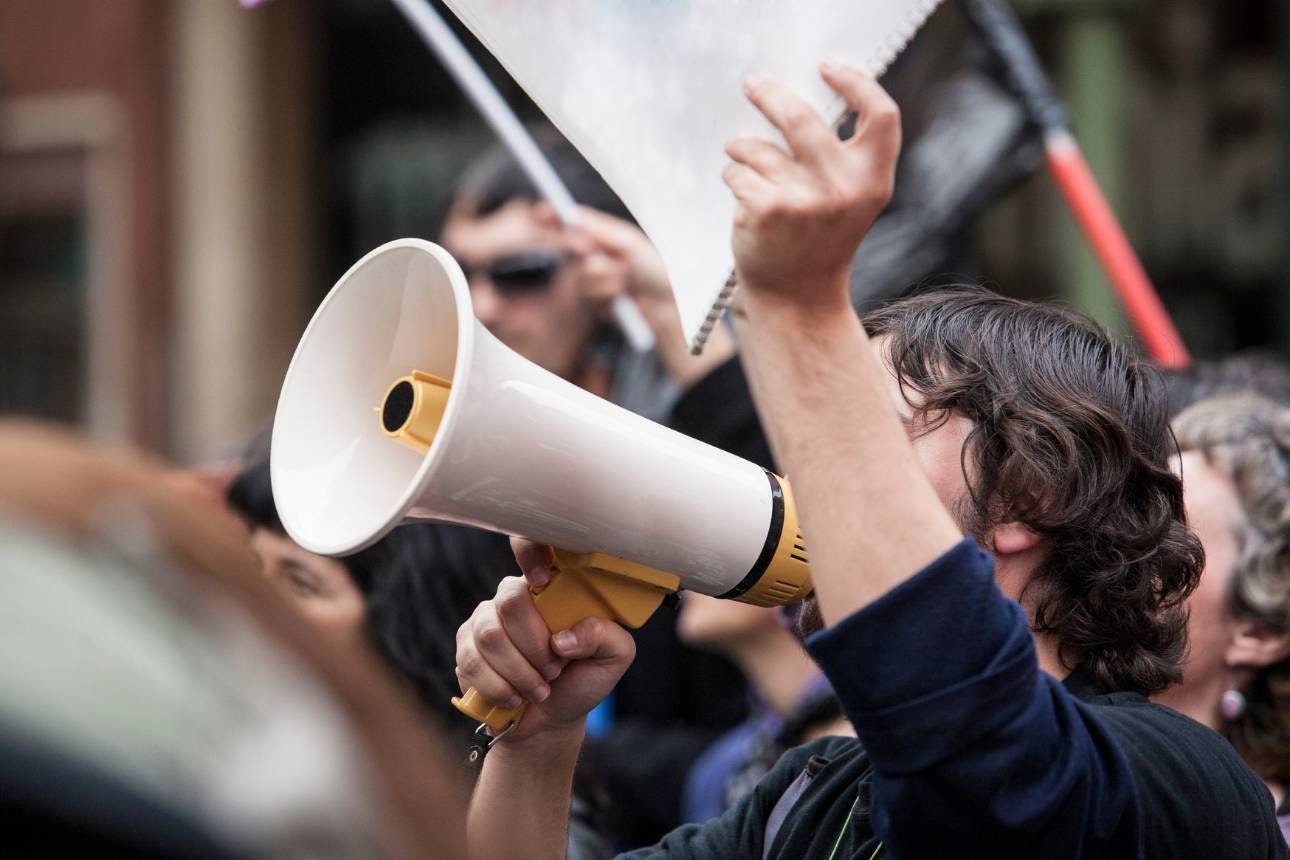 Image of a man protesting with a megaphone