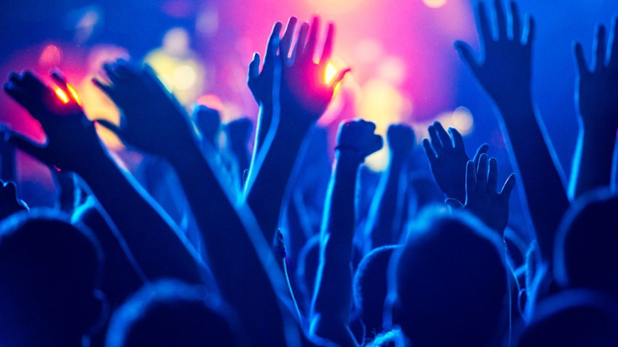 Image of hands up at a concert