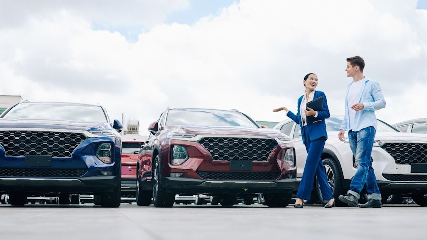 Image of a man walking past cars