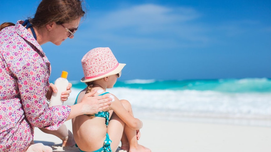 Image of a mother applying sunscreen on daughter