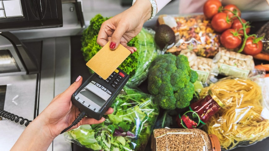 Image of person paying for groceries at the checkout