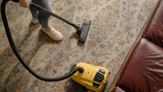 Person using vacuum cleaner at home.