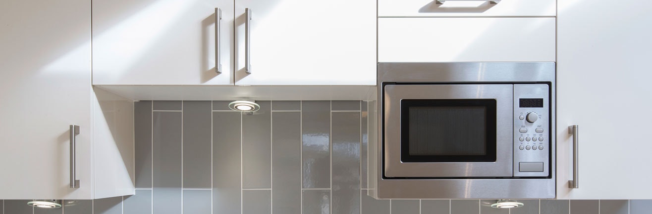 Microwave embedded in kitchen cabinet.