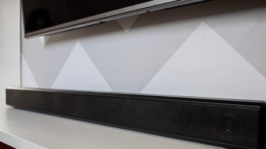 Photo of sound bar on cabinet below TV.