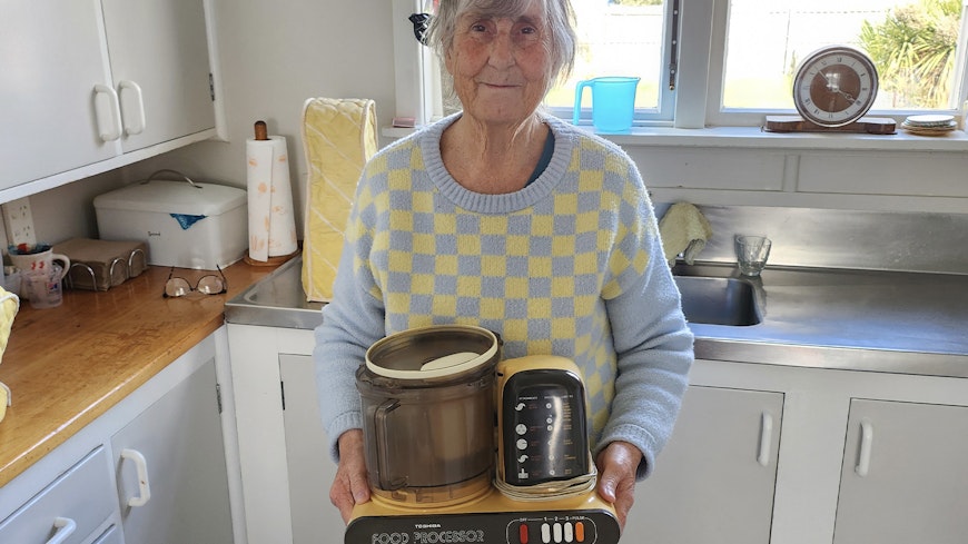Lady holding an old food processor.