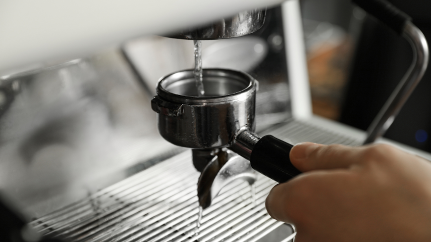 Image of woman cleaning portafilter on her coffee machine