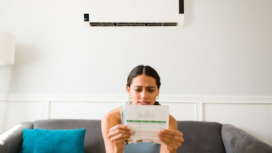 Woman looking distressed at power bill.