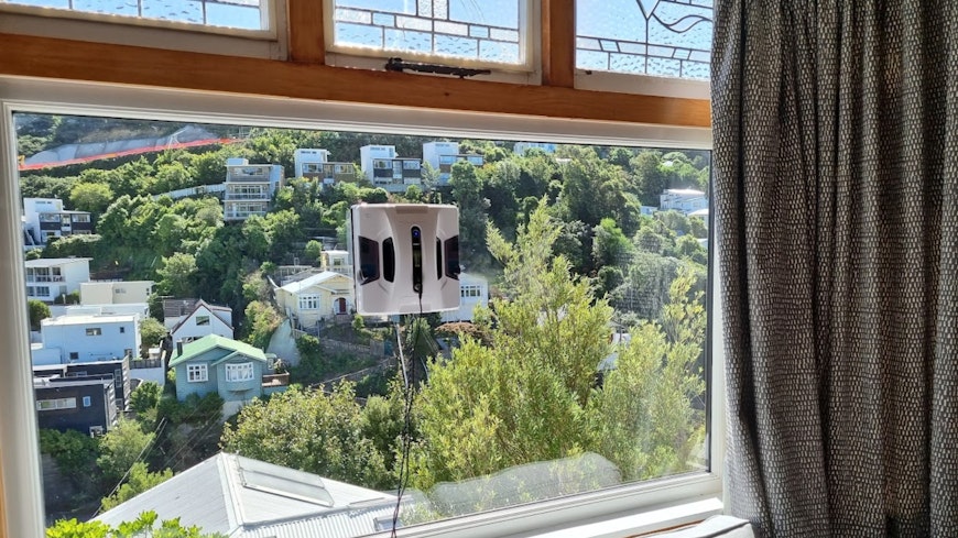 Window cleaning robot attached to window.