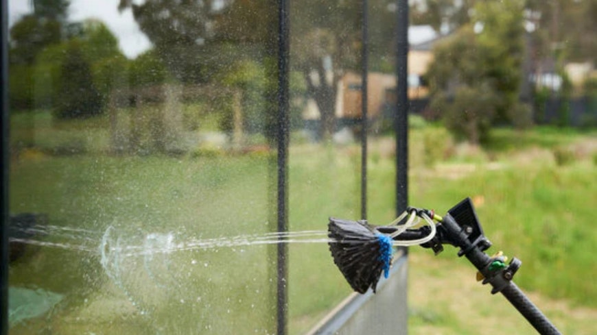 Water fed brush cleaning window.