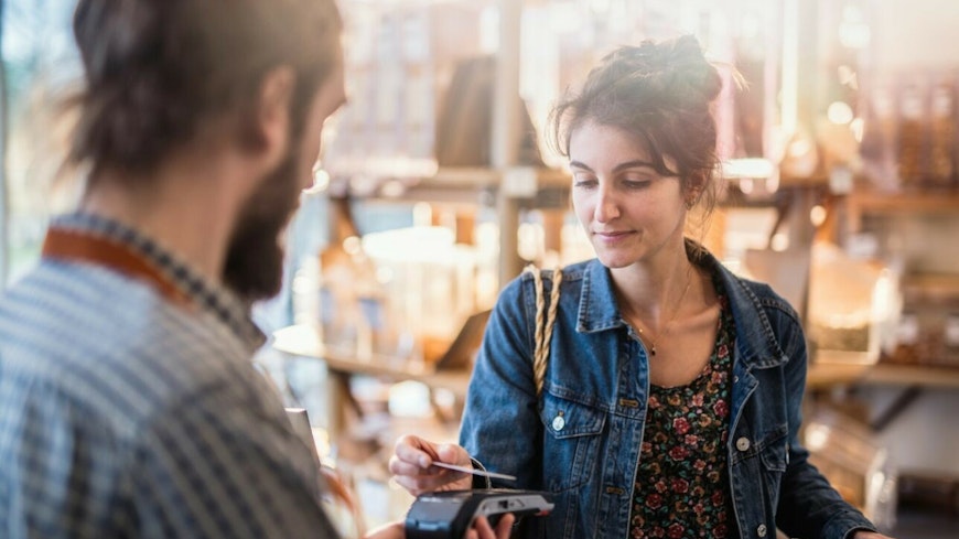 Woman paying with card, contactless payment.