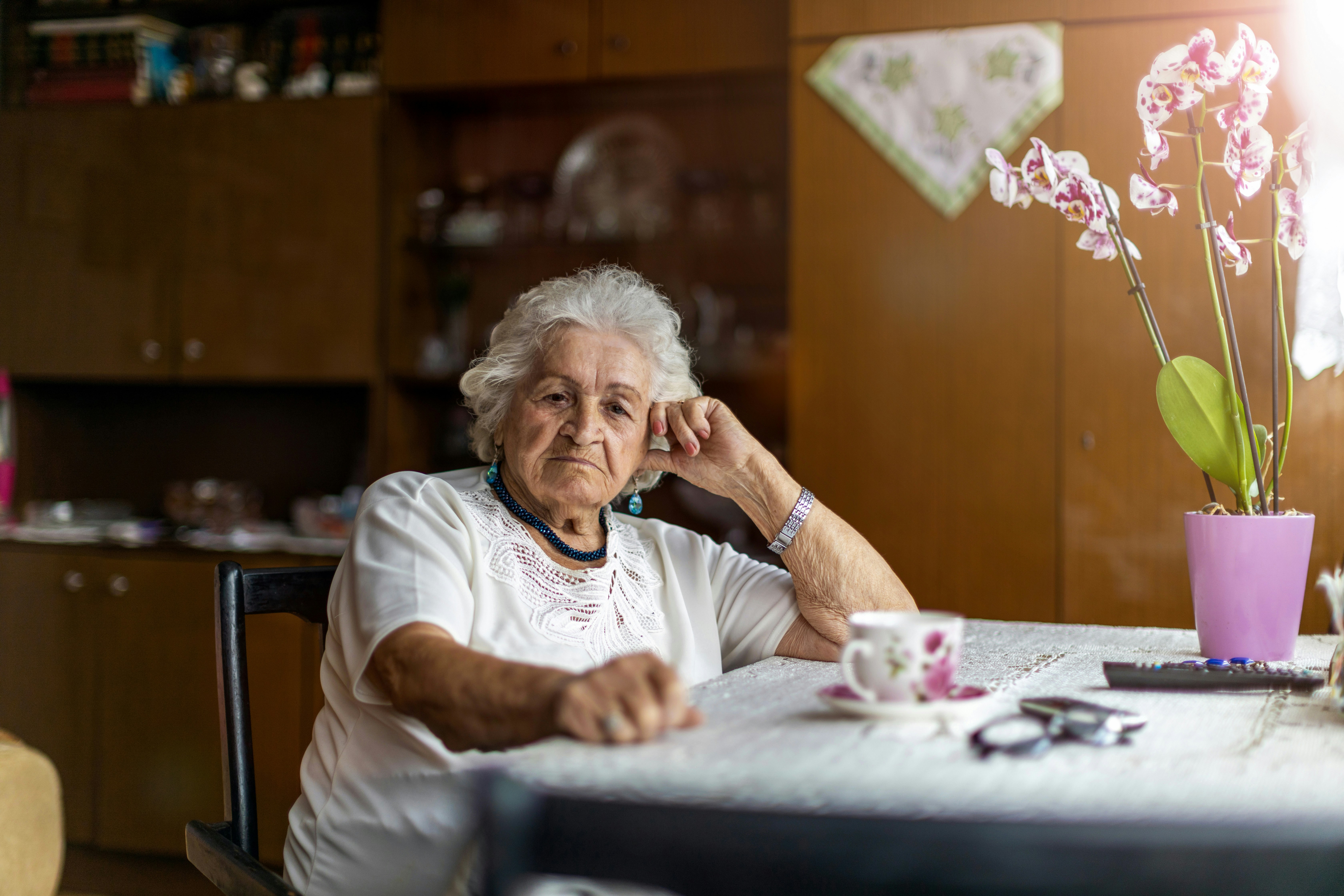 Older woman sitting at kitchen table.
